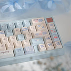 Keyboard keycaps with decorative patterns on a light blue base