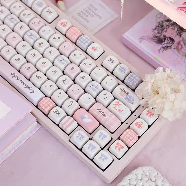 Pastel-colored keyboard on a pink surface with decorative elements