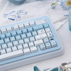 Light blue and white keyboard on a white surface with decorative items.