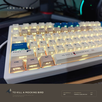 "To Kill a Mockingbird keycap set with side-engraved legends in cream and navy blue, 130-key layout shown."