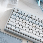 Mechanical keyboard with gray and white keys on a light surface