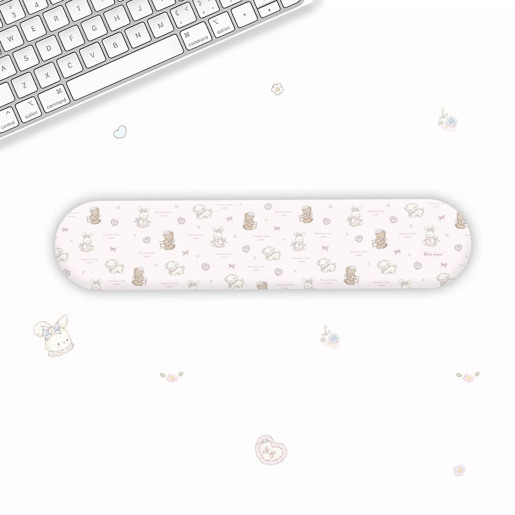 A long, narrow wrist rest with a cute pastel cartoon pattern of bears, hearts, and flowers, displayed on a clean white desk next to a keyboard.