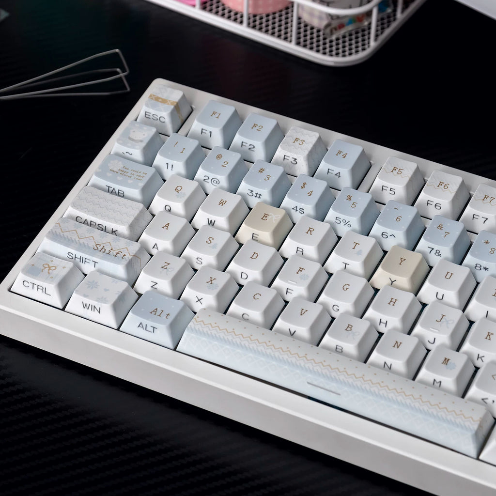 Close-up of a mechanical keyboard with gray and white keys on a dark surface.