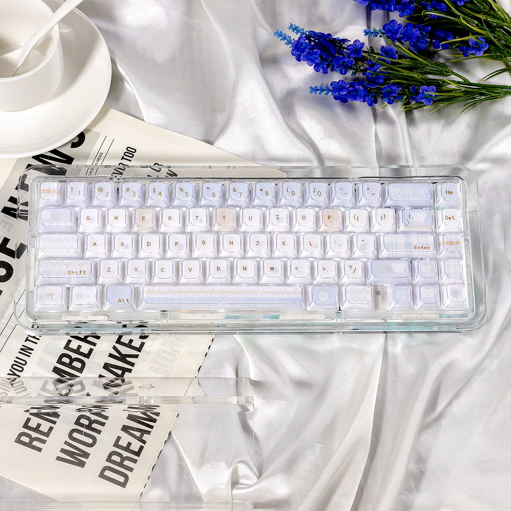 Clear mechanical keyboard on a white fabric background with flowers and text.