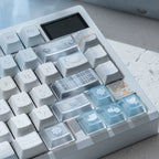 Close-up of a mechanical keyboard with custom keycaps on a light surface.