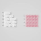 Comparison of white and pink silicone molds on a gray background