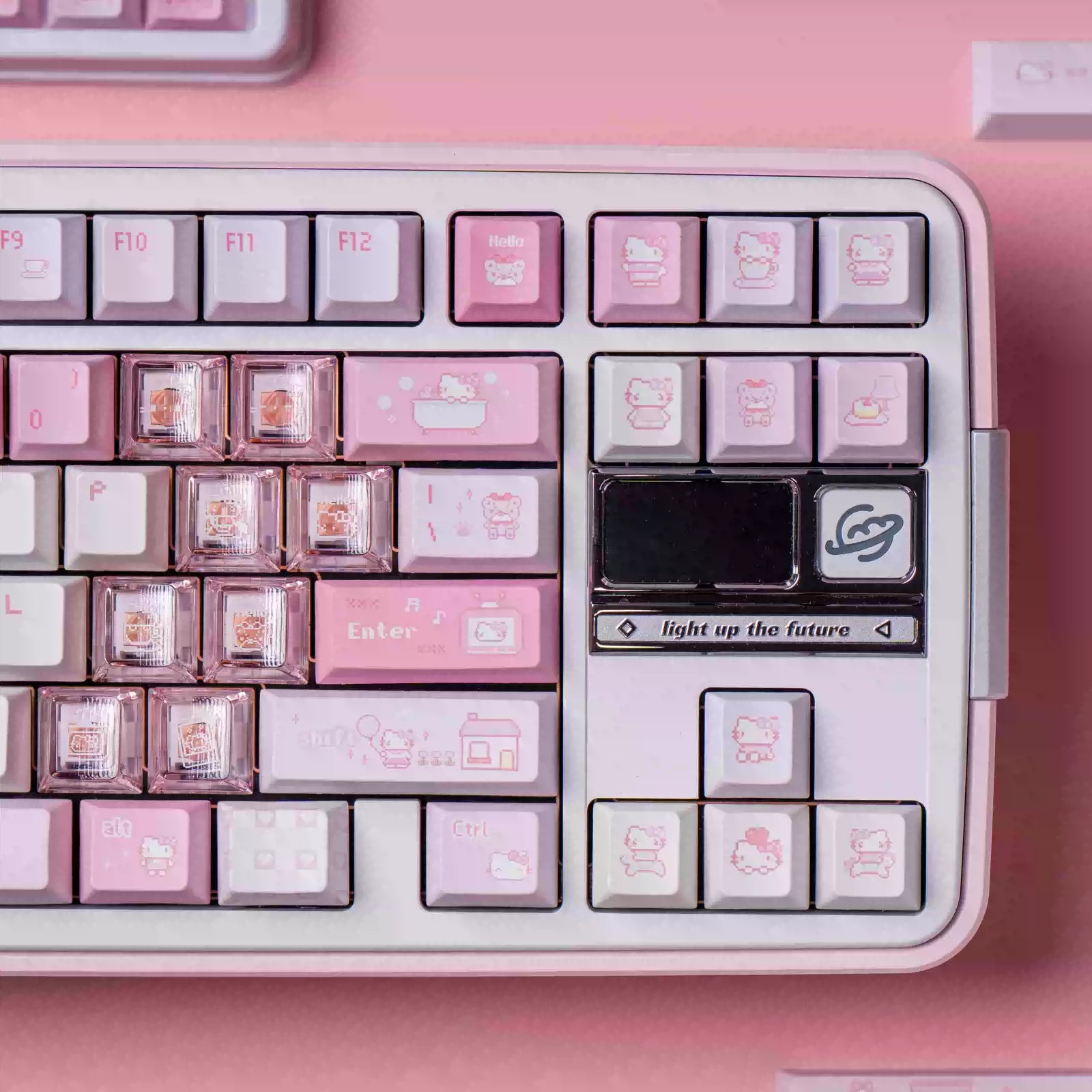 A close-up of a pastel pink mechanical keyboard with Hello Kitty themed keycaps, featuring pink, white, and lavender keys with cute illustrations, set against a matching pink background.