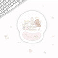 A round gel mouse pad with a pastel illustration of a fountain and two angel characters, shown on a white desk next to a keyboard. The pad has a pink wrist rest and the text 'Sweet dream' on it.